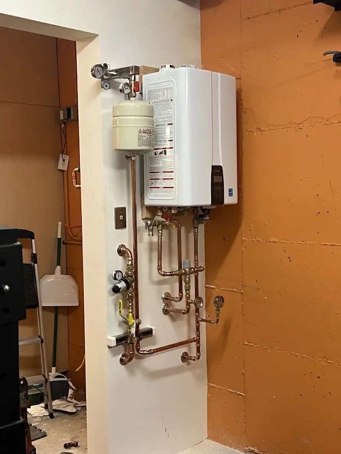 Plumbing technician inspecting water heater connections in Zebulon